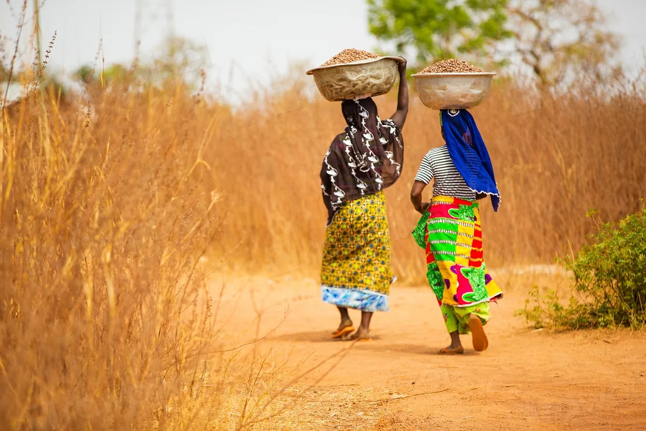 Women carrying harvest - community life across the mining value chain